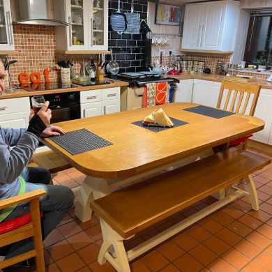 Country Oak 180cm Cream Painted Cross Leg Dining Table Oval Corners in a customers home with matching cream painted oak bench and carver dining chairs